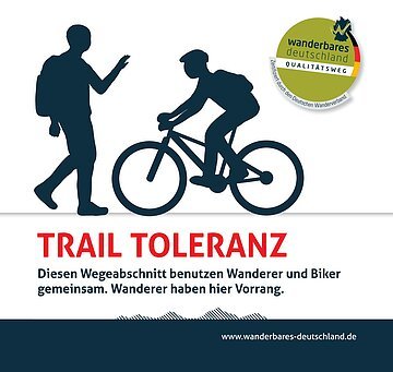 Trail Toleranz Das Schild zeigt einen Wanderer und einen Fahrradfahrer. Darunter steht der Text "Trail Toleranz - Diesen Wegeabschnitt benutzen Wanderer und Biker gemeinsam. Wanderer haben hier Vorrang."