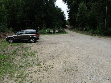 Parkplatz im Birktal Fläche mit Schotter auf dem ein Auto parkt. Es gehen verschiedene Wege von der Fläche weg.
