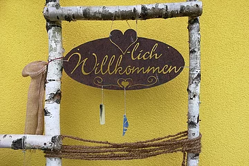 Willkommensschild mit Birkenastumrandung