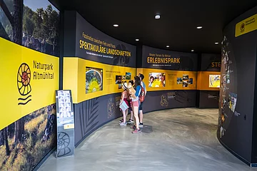 Eine Familie erforscht die Naturpark Altmühltal Ausstellung im Dinopark Denkendorf.